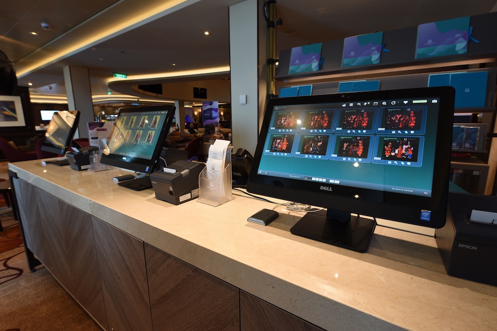 Image of 3 computer screens which are on a table, On the screens are images of peoples green screen photos.