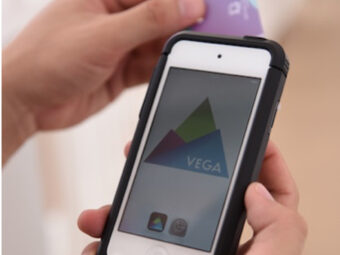 Image of two hands holding a phone which shows a software called VEGA to enable staff to tag a guests photos