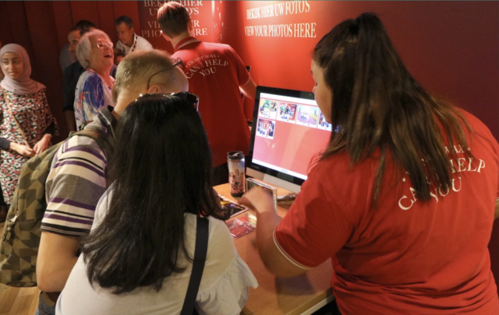 IMage of guests choosing their photos on a computer screen with the help of staff.
