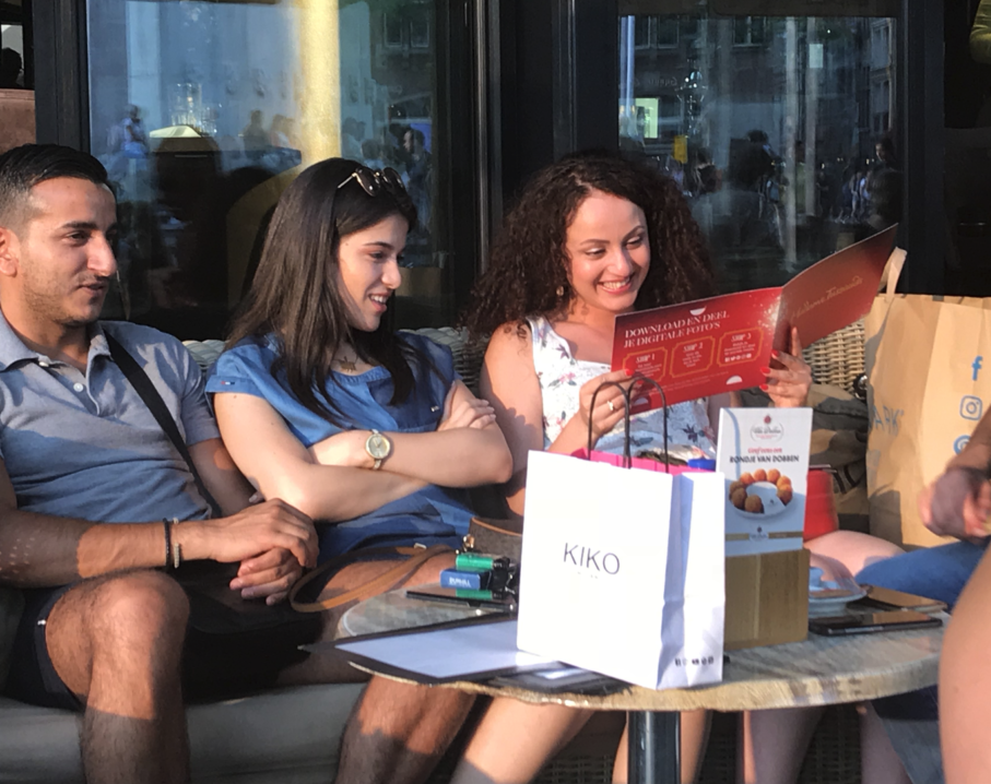 Image of three people looking at purchased photo booklets.